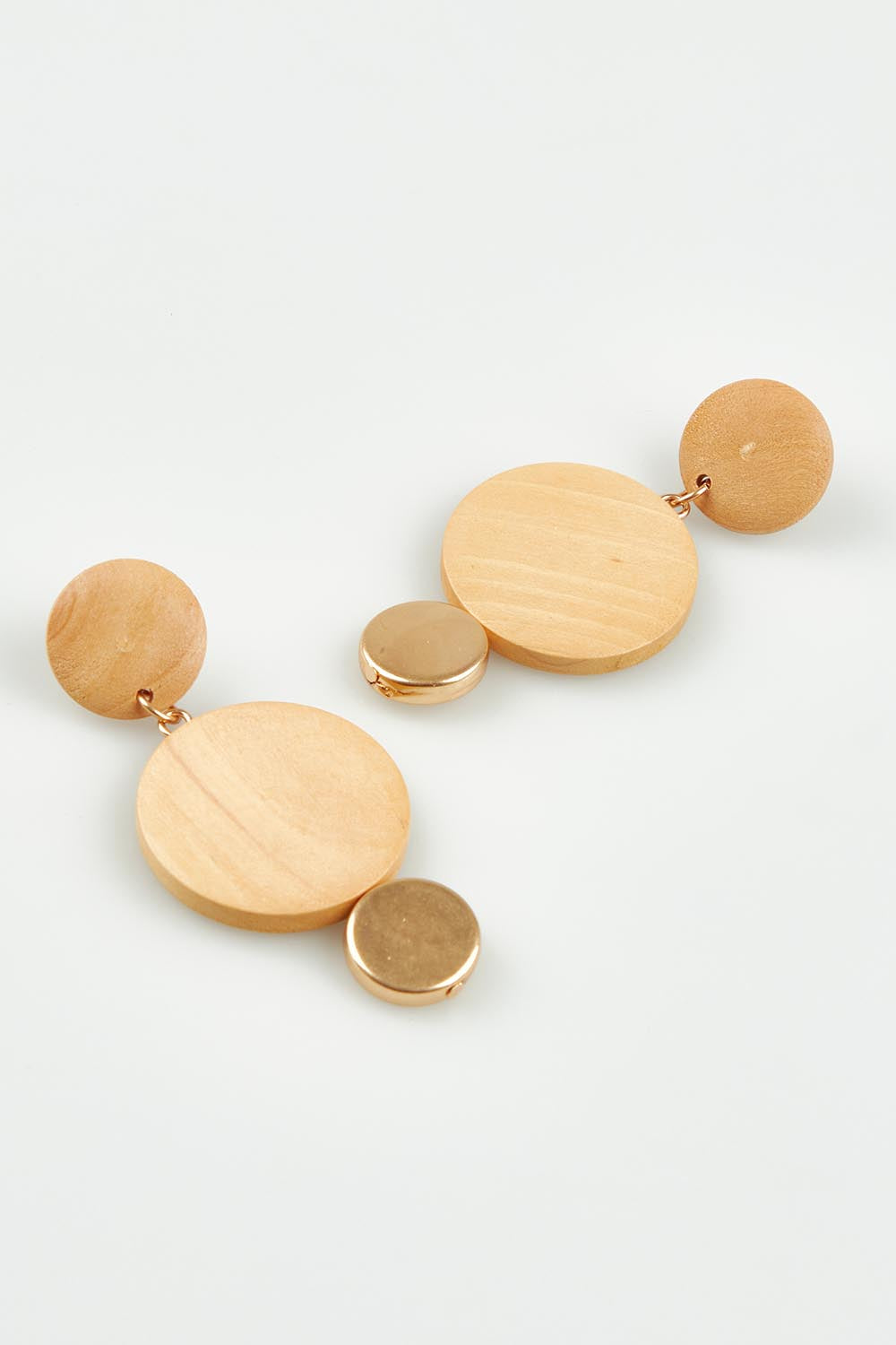 A model wearing the Lima Earrings in colour Natural, from the front, showing the whole outfit