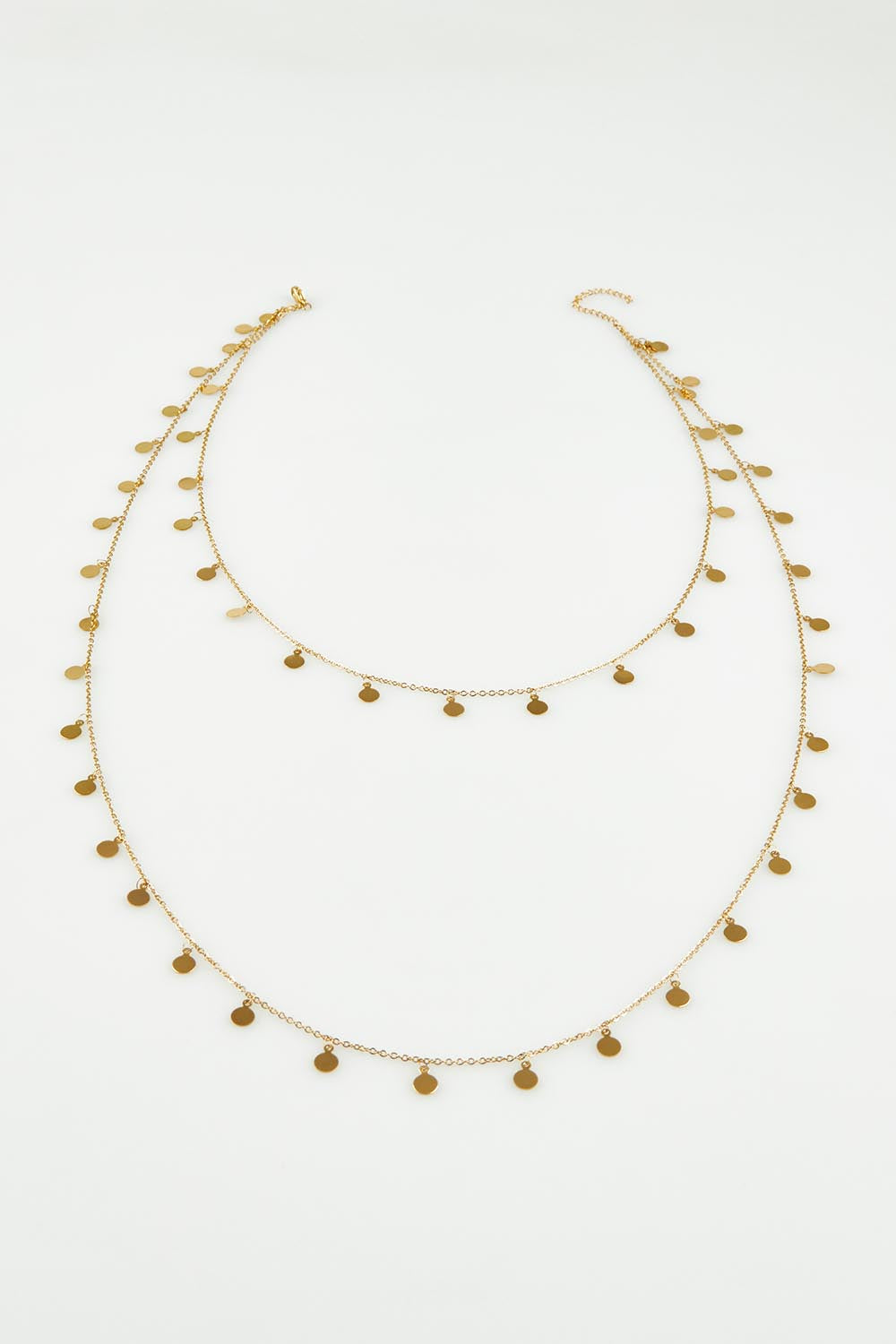 A model wearing the Cosmos Necklace in colour Gold (Metallics), from the front, showing the whole outfit