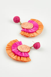 A model wearing the Torino Earrings in colour Pinkorange, from the front, showing the whole outfit