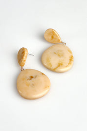 A model wearing the Morocco Earring in colour Natural, from the front, showing the whole outfit