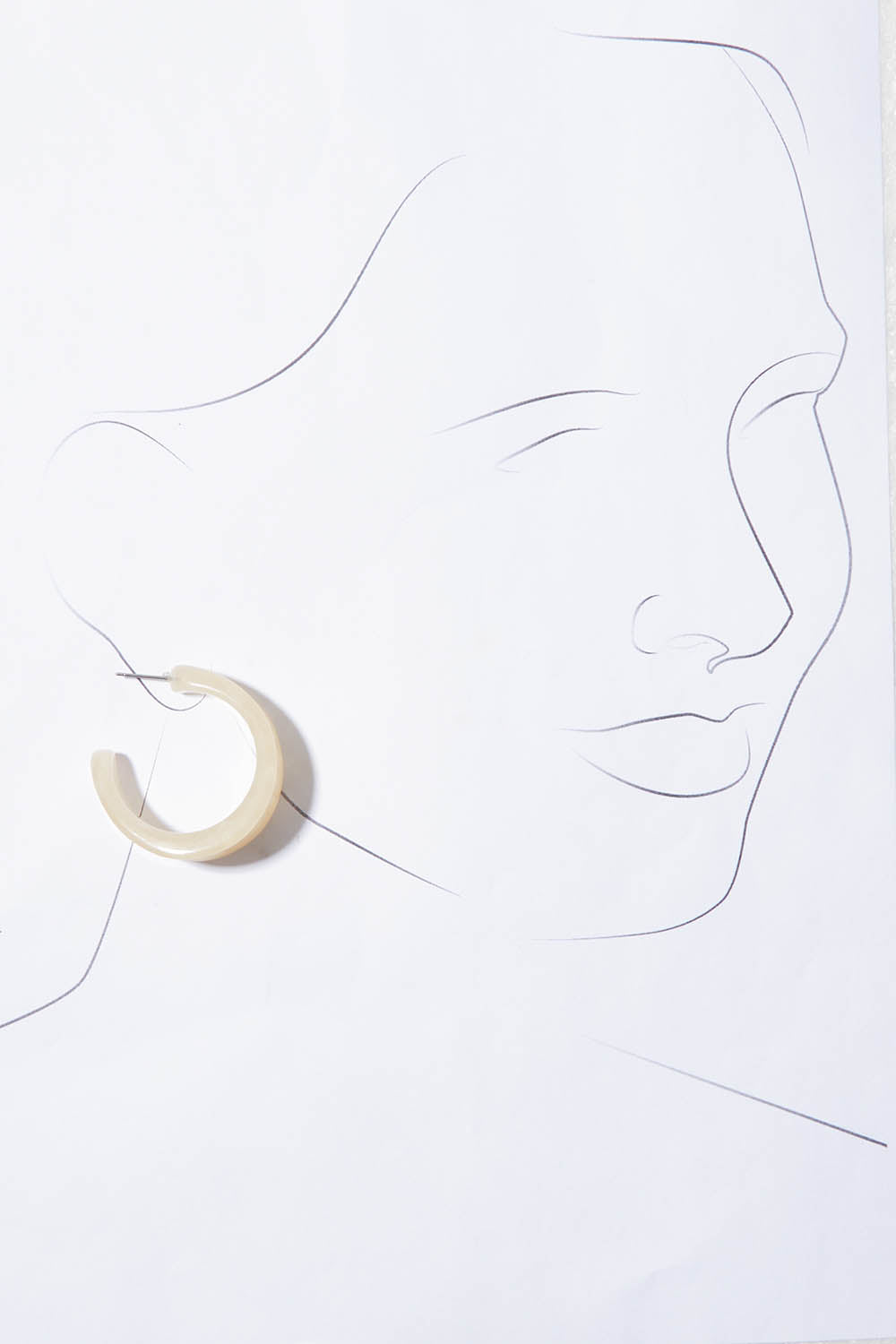 A model wearing the Fairley Earrings in colour Natural, from the front, showing the whole outfit