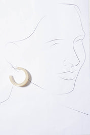 A model wearing the Fairley Earrings in colour Natural, from the front, showing the whole outfit
