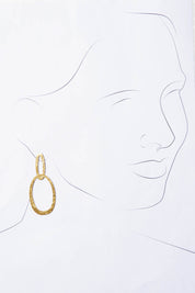 A model wearing the Pegasus Earrings in colour Gold (Metallics), from the front, showing the whole outfit