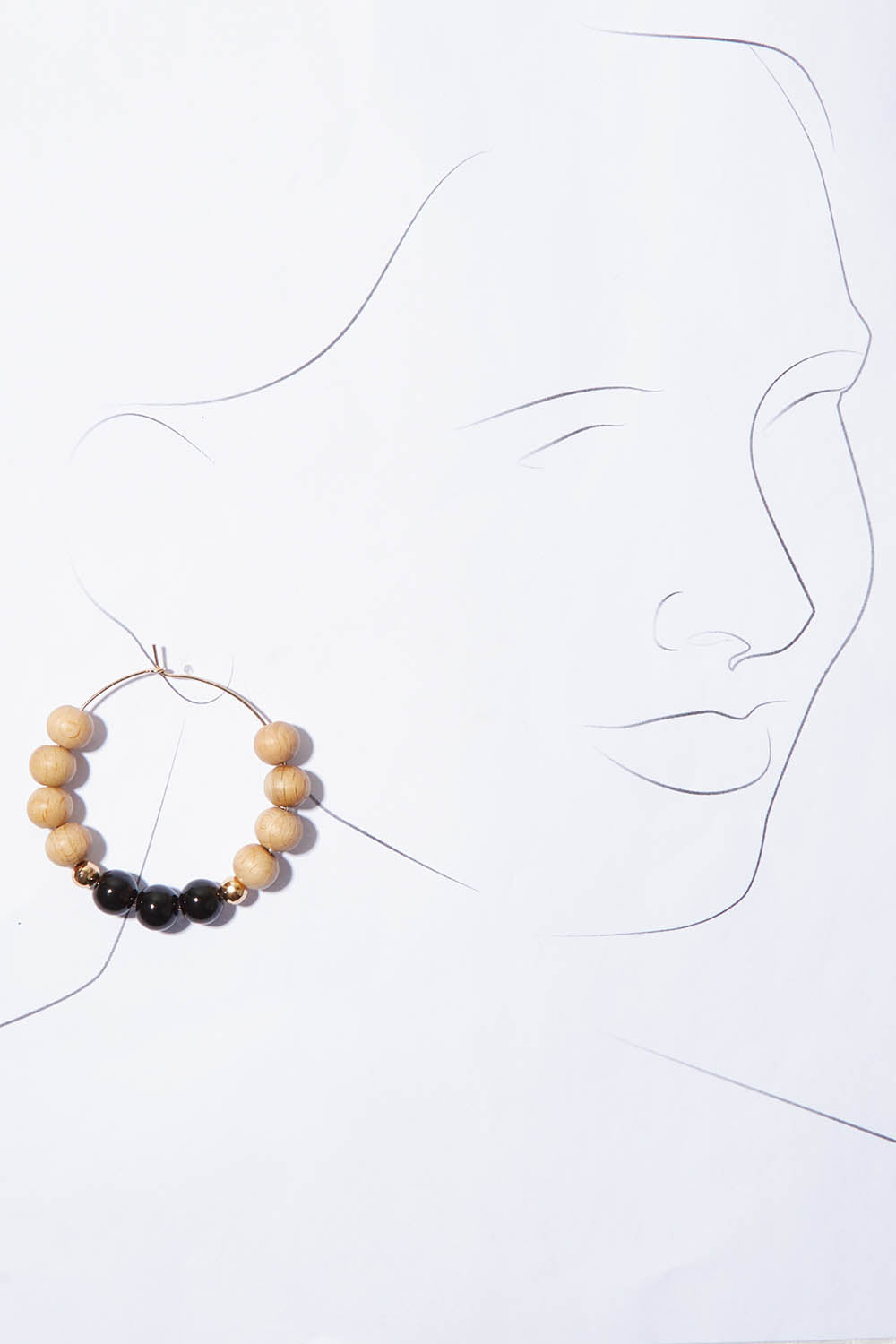 A model wearing the Shadow Stone Hoop Earrings in colour Black (Black), from the front, showing the whole outfit