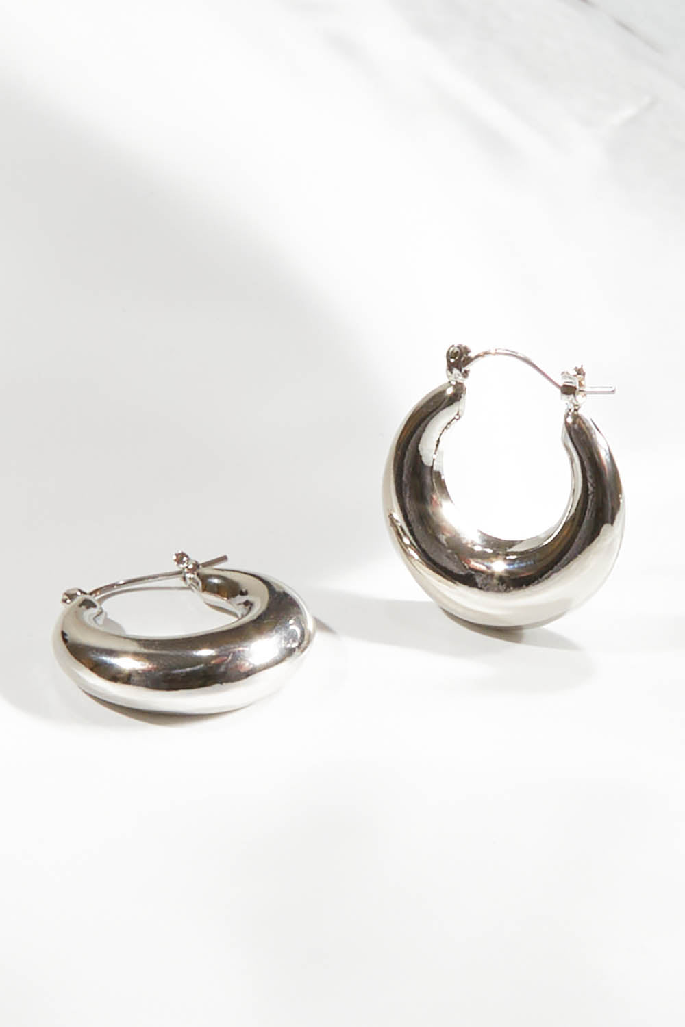 A model wearing size OneSize of the Fergie Earrings Small in colour Silver (Metallics), from the front, showing the whole outfit