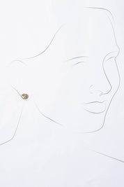 A model wearing the Madga Earrings in colour Gold (Metallics), from the front, showing the whole outfit