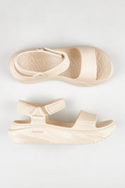 A model wearing size 7 of the Cloud Nine Eva Sandal in colour Sand, from the front, showing the whole outfit