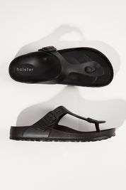 A model wearing size 6 of the Coastal EVA Slide in colour Black (Black), from the front, showing the whole outfit