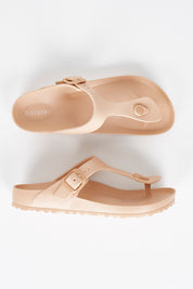 A model wearing size 7 of the Coastal EVA Slide in colour Tan, from the front, showing the whole outfit