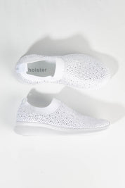 A model wearing size 7 of the Firefly Sneaker in colour White (White), from the front, showing the whole outfit