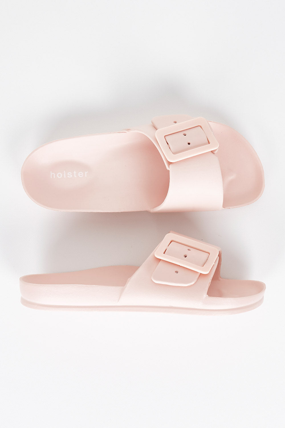 A model wearing size 7 of the Solace EVA Slide in colour Blush (Pink), from the front, showing the whole outfit