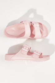 A model wearing size 6 of the Sundreamer EVA Slide in colour Blush (Pink), from the front, showing the whole outfit