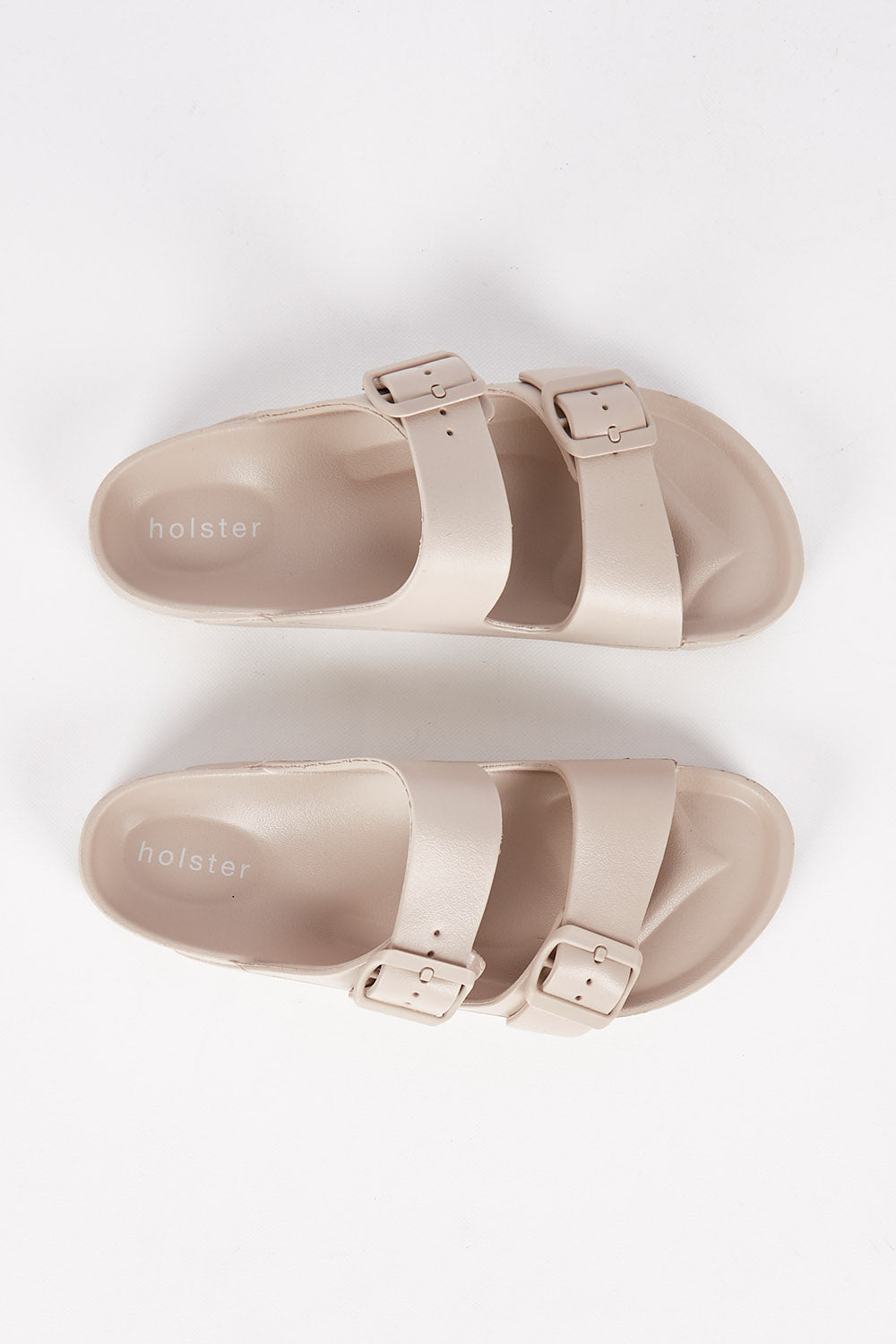 A model wearing size 7 of the Sundreamer EVA Slide in colour Sand, from the front, showing the whole outfit