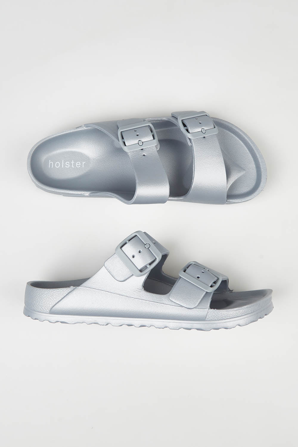 A model wearing size 7 of the Sundreamer EVA Slide in colour Silver (Grey), from the front, showing the whole outfit