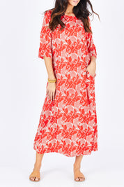 Model Gemma wearing size S of the Carabou Dress in colour NemoRed (Red), from the front, cropped image