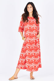 Model Gemma wearing size S of the Carabou Dress in colour NemoRed (Red), from the front, showing the whole outfit