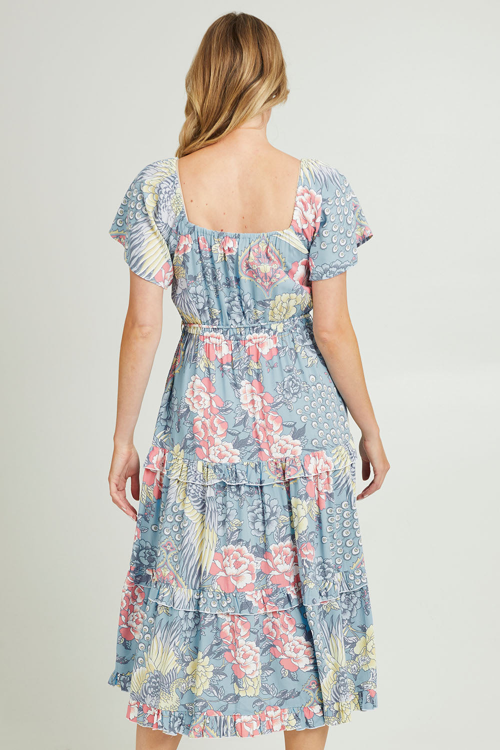 Model Grace wearing size 10 of the Siesta Dress in colour Birdgarden (Blue), from the back