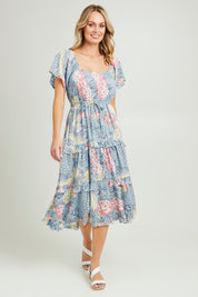 Model Grace wearing size 10 of the Siesta Dress in colour Birdgarden (Blue), from the front, showing the whole outfit
