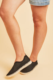 A model wearing size 37 of the Tulip Sneaker in colour Black (Black), from the front, cropped image