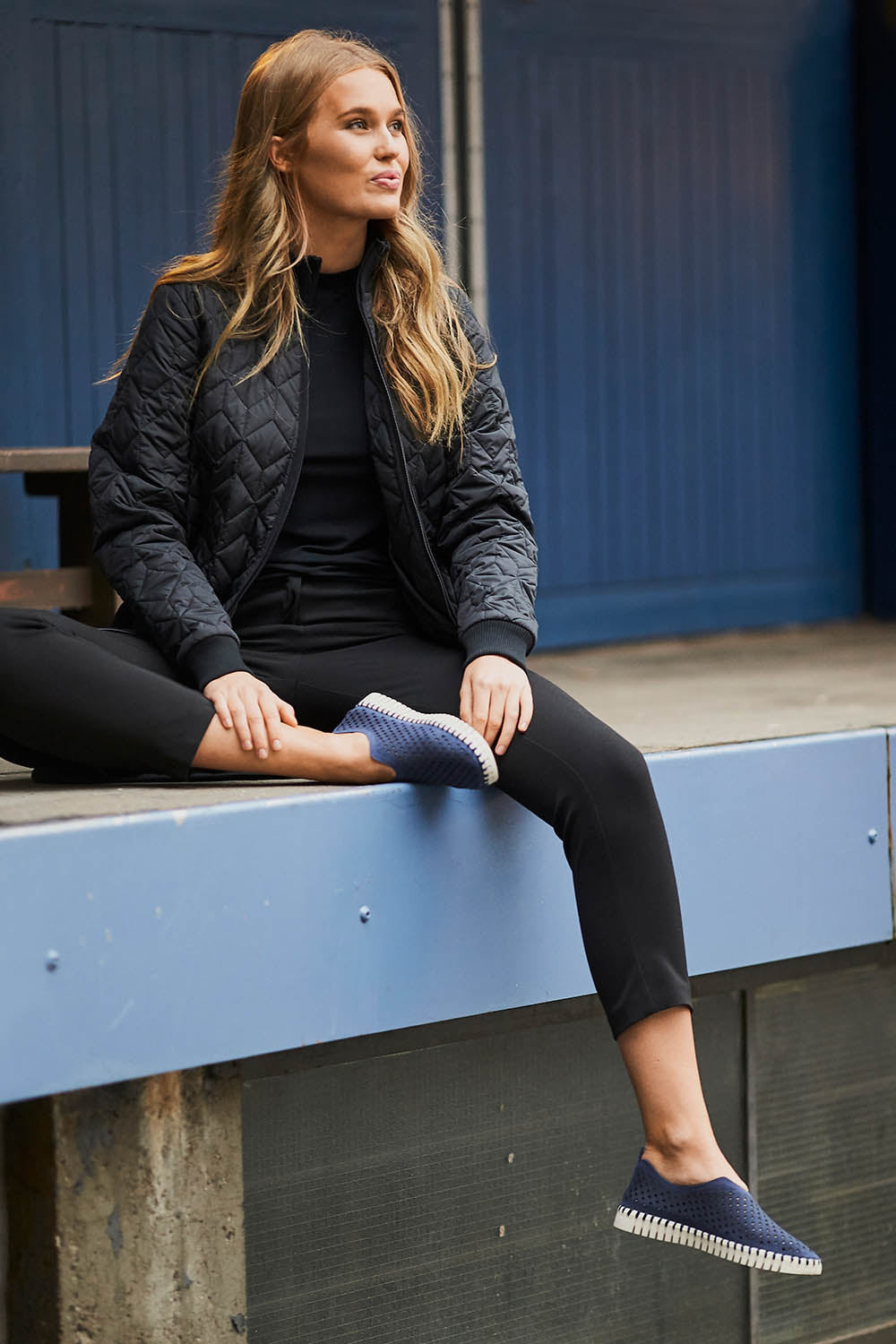 A model wearing the Tulip Sneaker in colour Drkindigo (Blue), from the front, showing the whole outfit