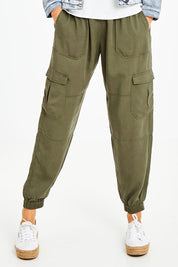 Model Naomi wearing size 10 of the Cecily Cargo Joggers in colour Khaki (Green), from the front, cropped image