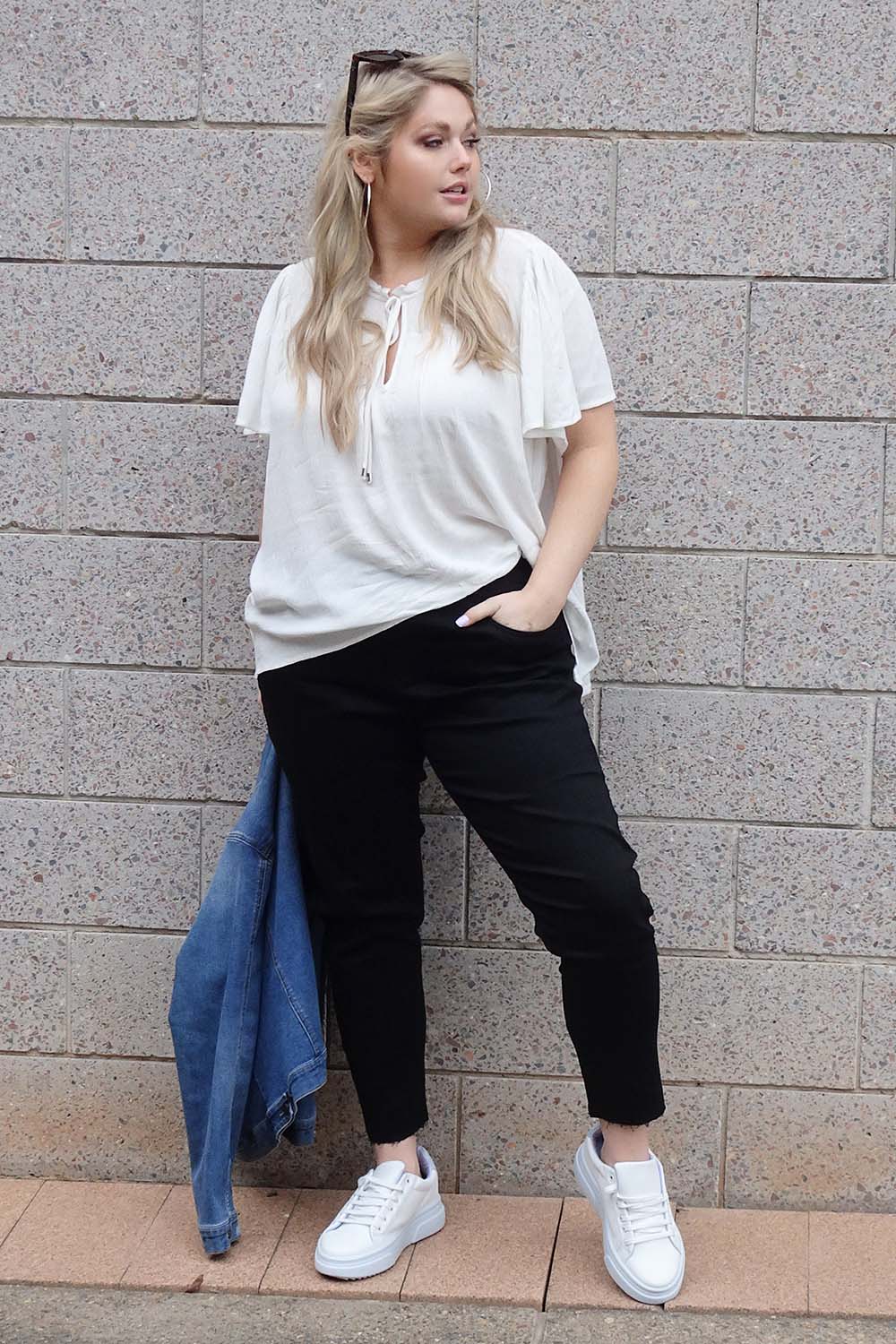 A model wearing the Frances Flutter Sleeve Top in colour White (White), from the front, showing the whole outfit