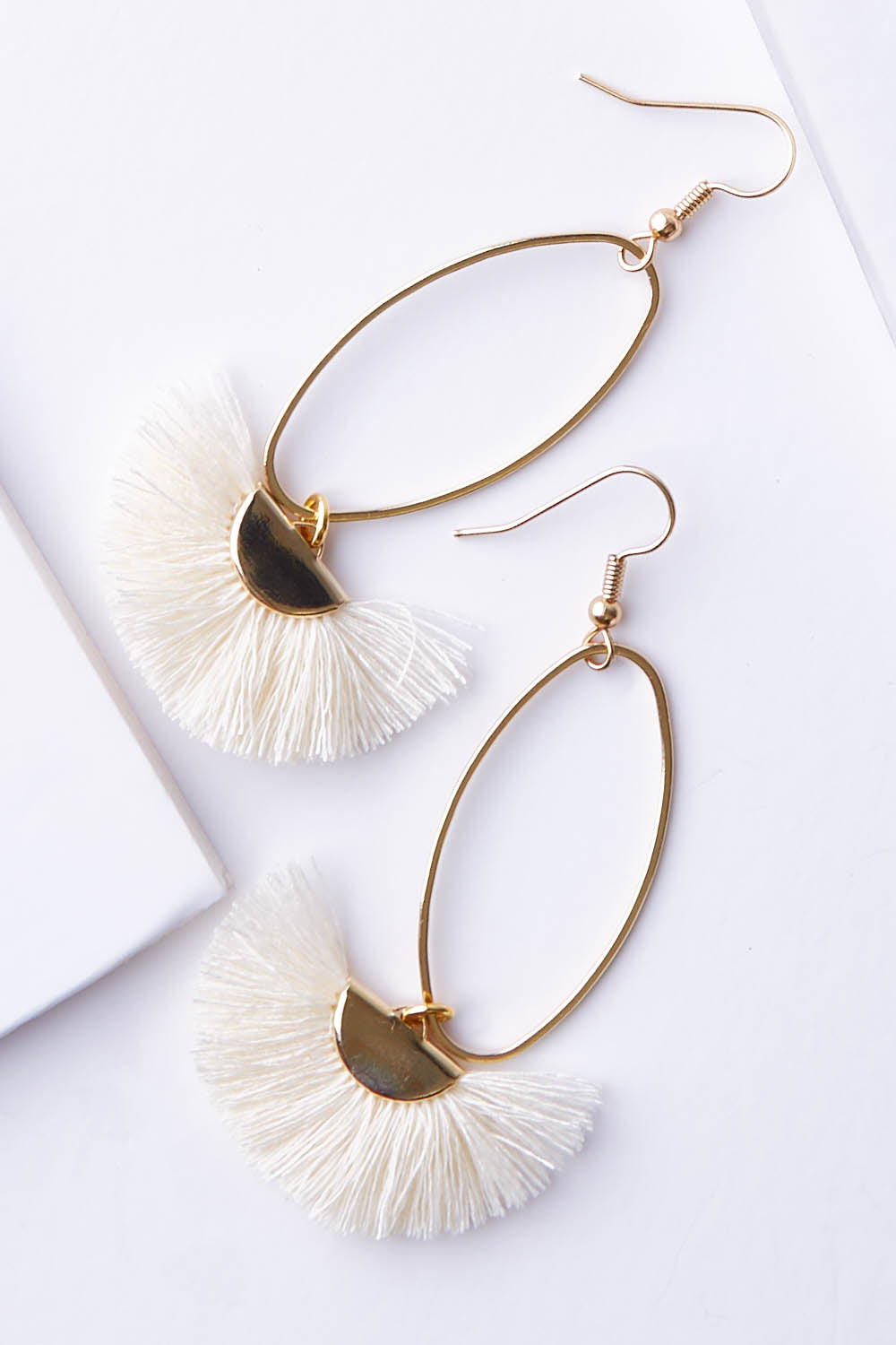 A model wearing size OneSize of the Caprioska Tassel Earrings in colour Ivory (White), from the front, showing the whole outfit