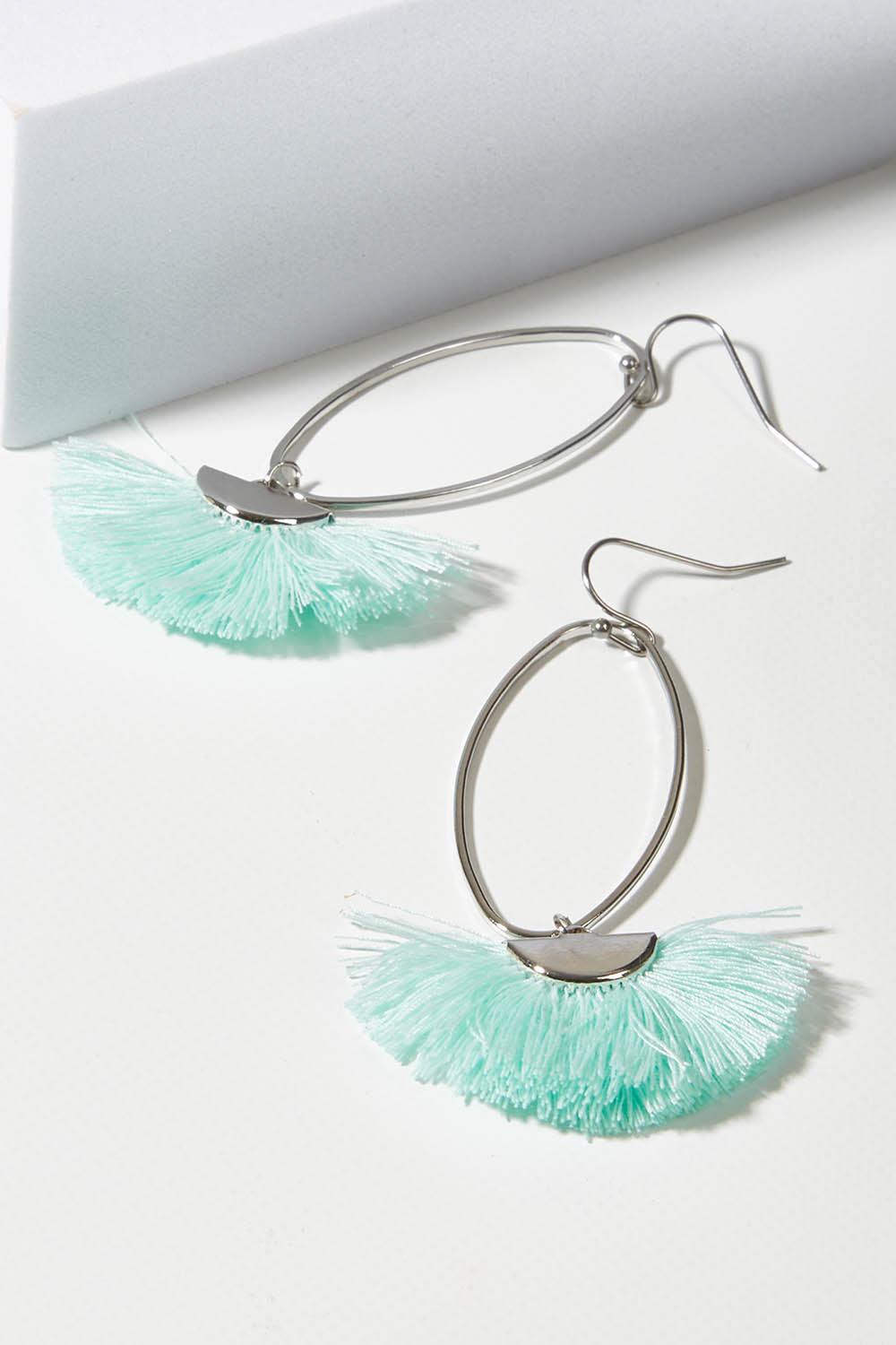 A model wearing size OneSize of the Silver Caprioska Tassel Earrings in colour Mint (Green), from the front, showing the whole outfit