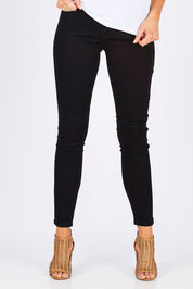 Model Madeline wearing size 10 of The Twiggy Mid Rise Skinny in colour Black (Black), from the front, cropped image