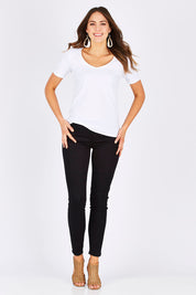 Model Madeline wearing size 10 of The Twiggy Mid Rise Skinny in colour Black (Black), from the front, showing the whole outfit