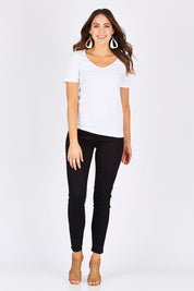 Model Madeline wearing size 10 of The Twiggy Mid Rise Skinny in colour Black (Black), from the front, showing the whole outfit