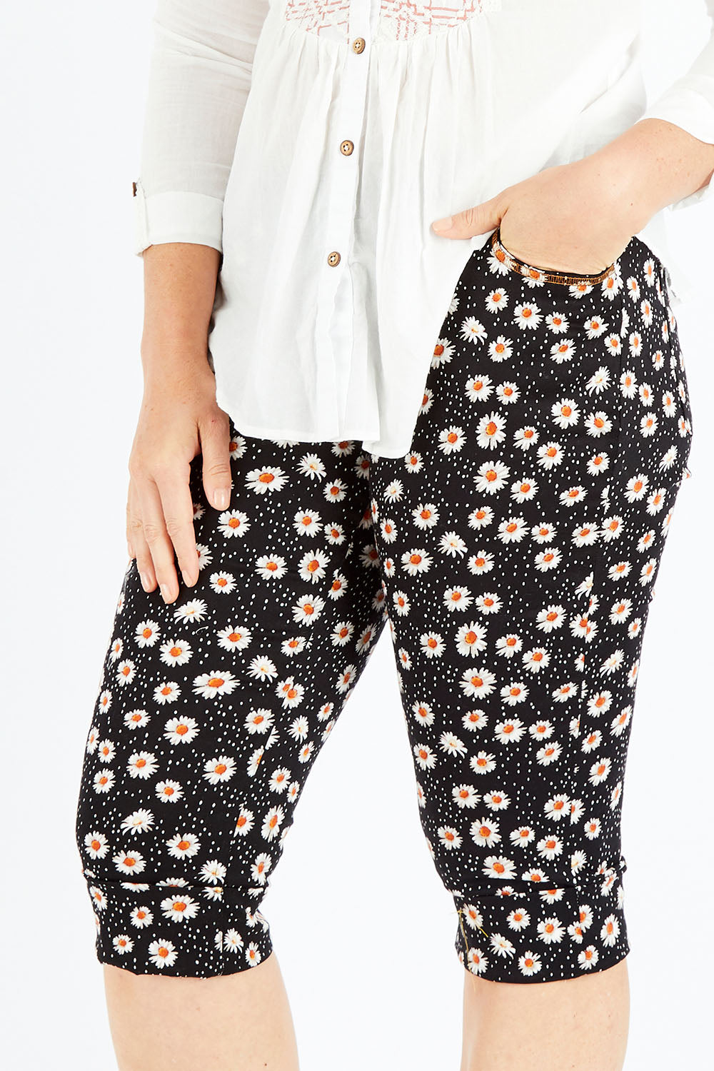 Model Shadae wearing size 10 of the Delightful Daisy Capri Pants in colour Blackmulti (Black), from the front, cropped image