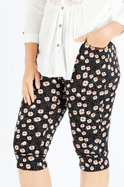 Model Shadae wearing size 10 of the Delightful Daisy Capri Pants in colour Blackmulti (Black), from the front, cropped image