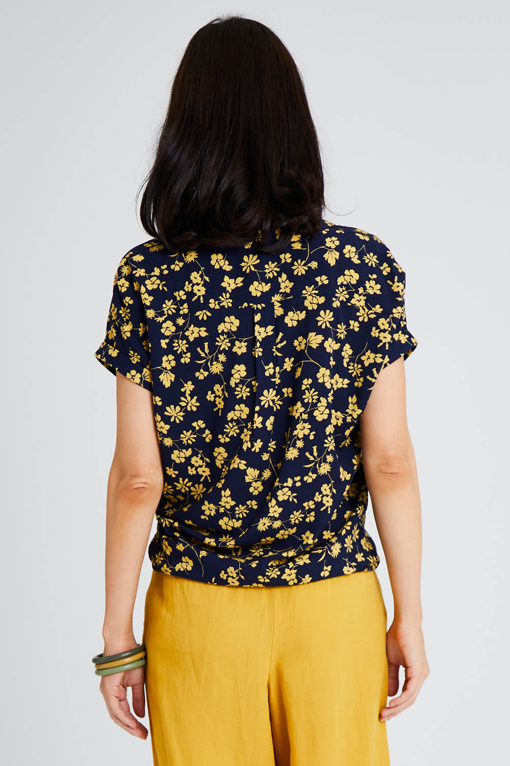 Model Andrea wearing size 10 of the Dela Shirt in colour Navyflora (Blue), from the back