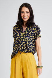 Model Andrea wearing size 10 of the Dela Shirt in colour Navyflora (Blue), from the front, cropped image