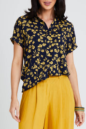 Model Andrea wearing size 10 of the Dela Shirt in colour Navyflora (Blue), from the front, cropped image