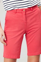 A model wearing the Cruise Longer Length Shorts in colour Poppy (Pink), from the front, cropped image