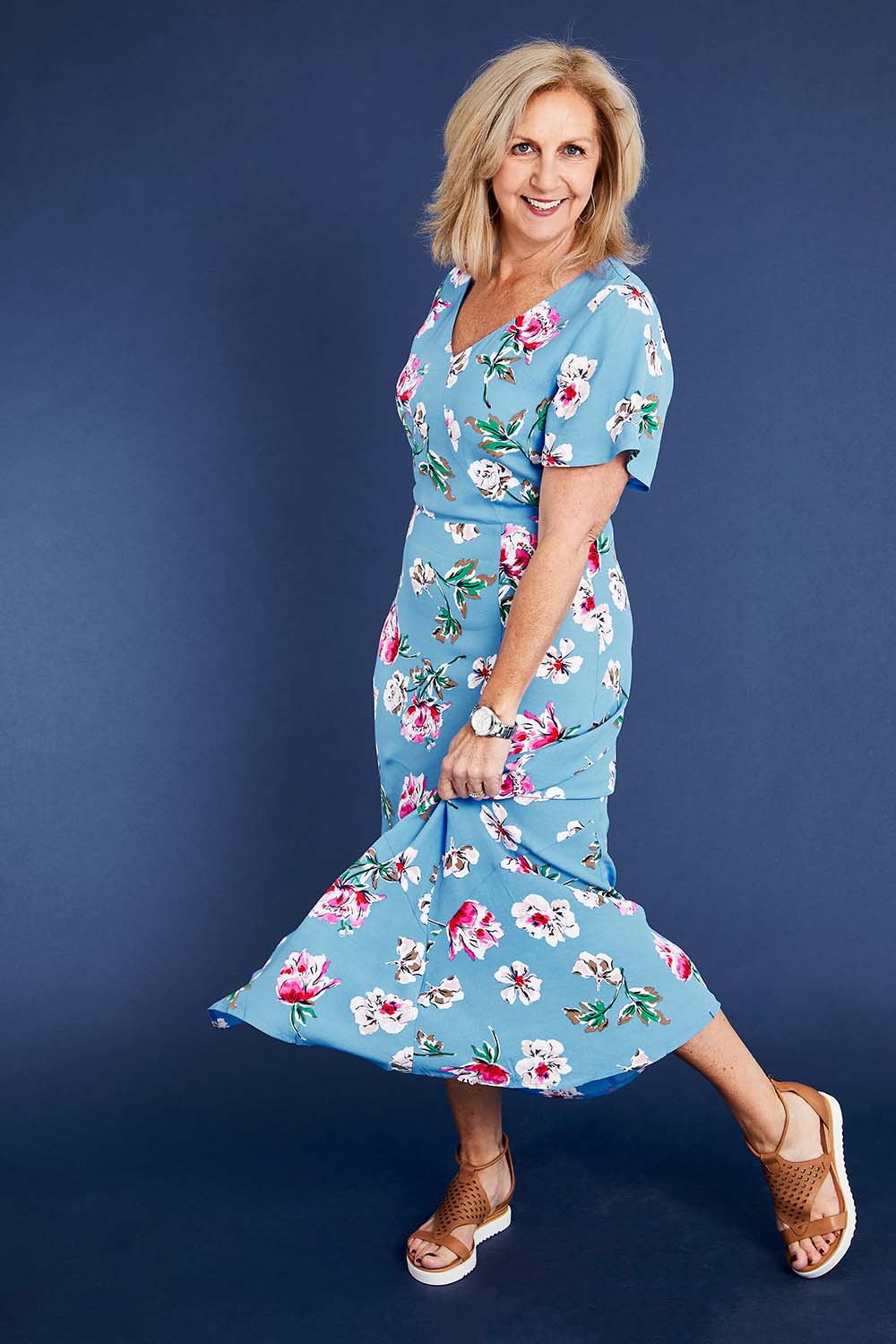Model Sandy wearing size 12 of the Alliana V Neck Dress in colour Blufloral (Blue), from the front, showing the whole outfit
