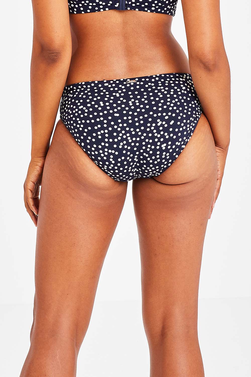 Model Olivia wearing size 10 of the Belle Bikini Bottom in colour Navyspot (Blue), from the back