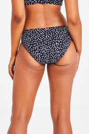 Model Olivia wearing size 10 of the Belle Bikini Bottom in colour Navyspot (Blue), from the back