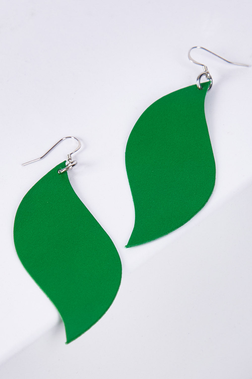 A model wearing size OneSize of the Australian Made Bold Single Leaf Leather Earring in colour Emerald (Green), from the front, showing the whole outfit