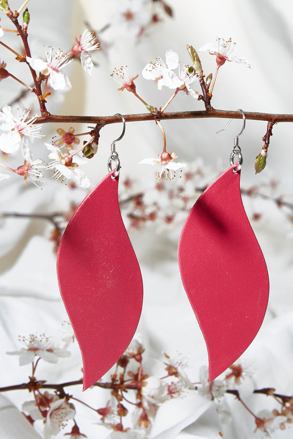 A model wearing size OneSize of the Australian Made Bold Single Leaf Leather Earring in colour Fuschia (Pink), from the front, showing the whole outfit