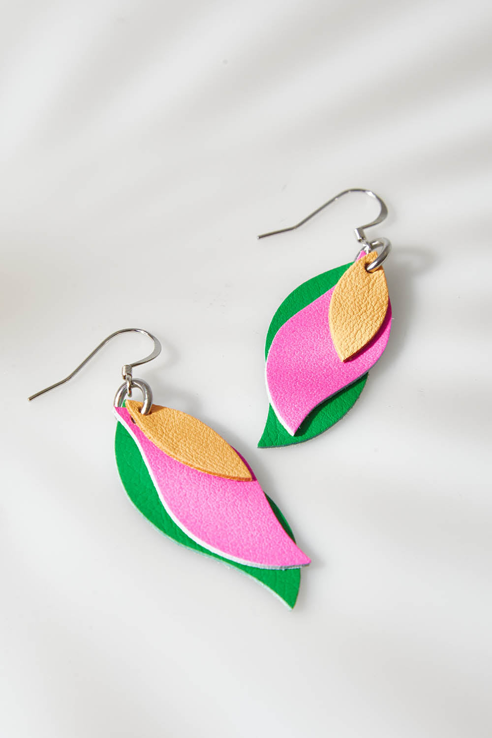A model wearing size OneSize of the Australian Made Leather Leaf Earring in colour Pinkgreen (Pink), from the front, showing the whole outfit