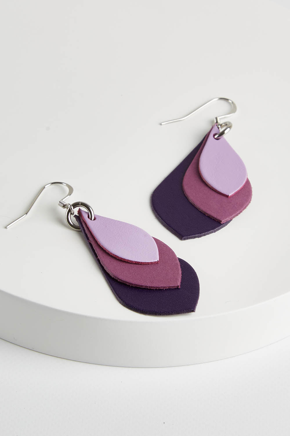 A model wearing size OneSize of the Australian Made Leather Teardrop Earring in colour Purple (Purple), from the front, showing the whole outfit