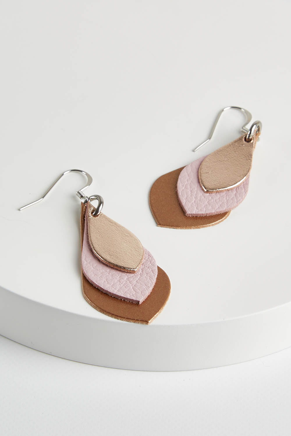 A model wearing size OneSize of the Australian Made Leather Teardrop Earring in colour Softpink (Pink), from the front, showing the whole outfit