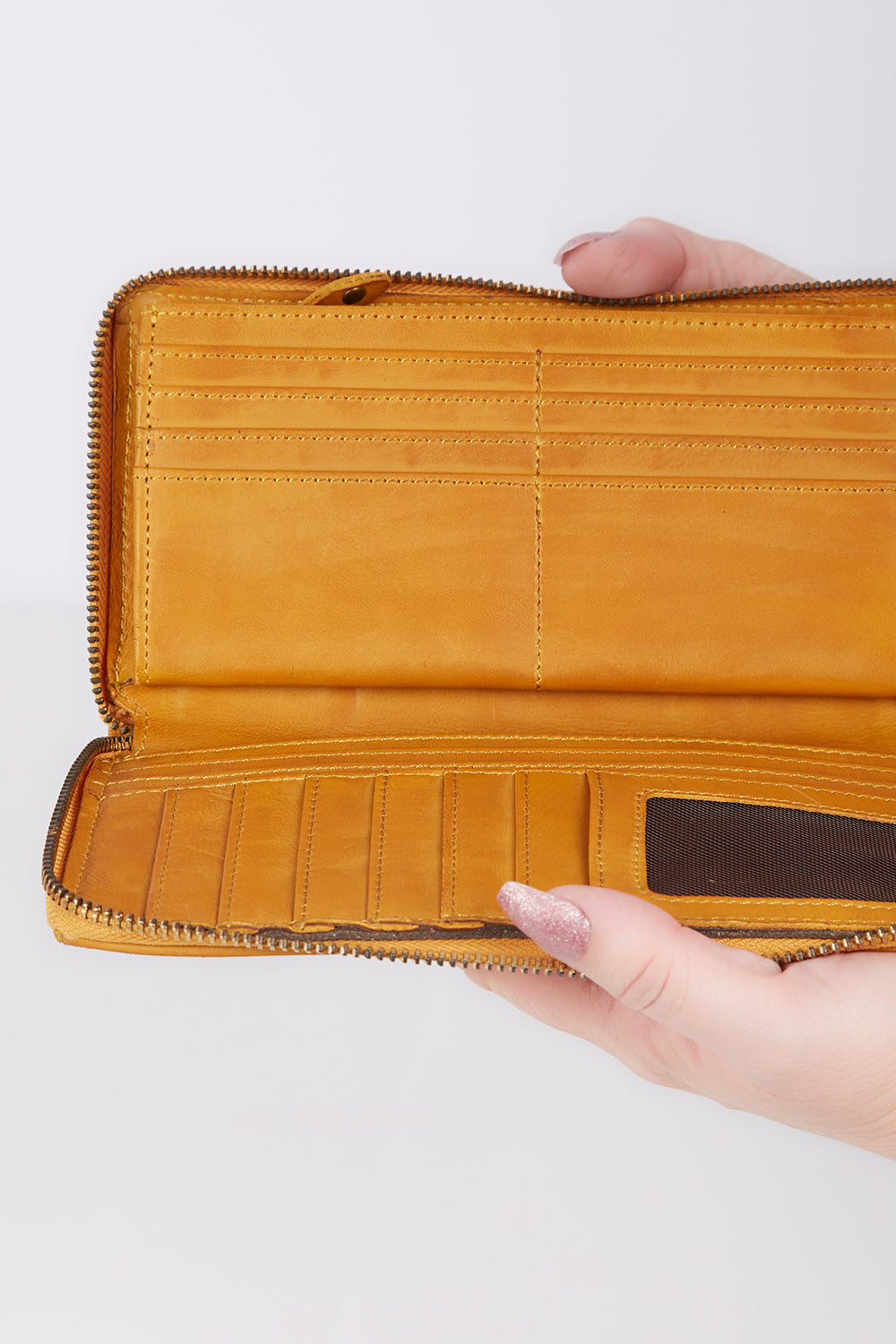 A model wearing size OneSize of the Tilly Leather Zip Around Wallet in colour Mustard, from the front, showing the whole outfit