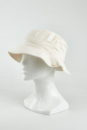 A model wearing the Tullamore Cotton Bucket Hat in colour Natural, from the front, showing the whole outfit