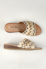 A model wearing the Ganni Slide in colour Natural, from the front, showing the whole outfit