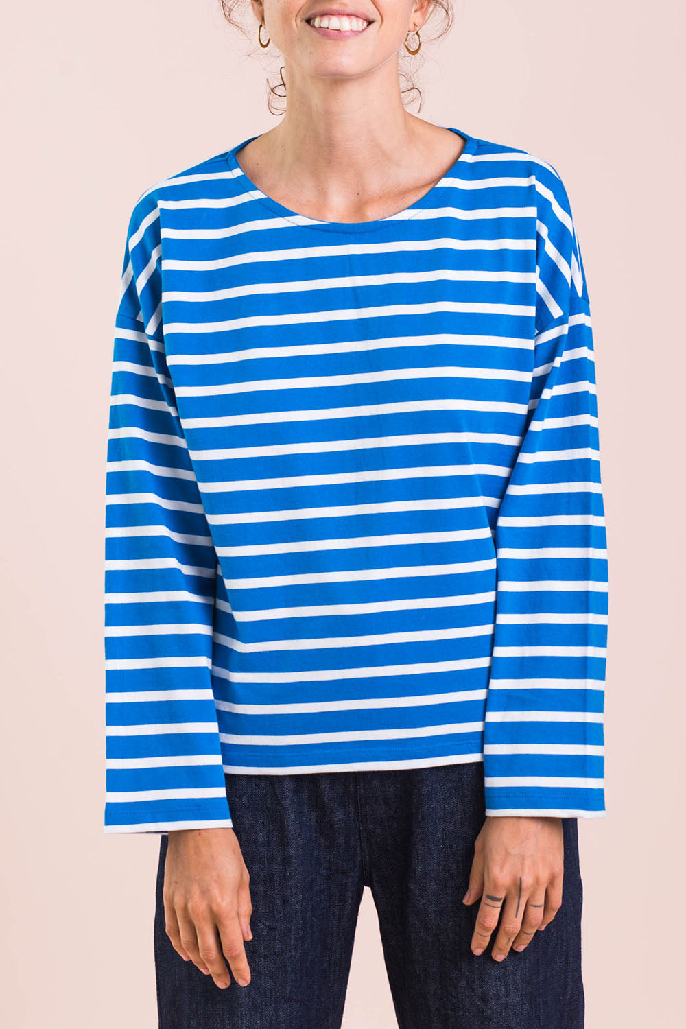 A model wearing the Brigitte Tee in colour Cobalt (Blue), from the front, cropped image