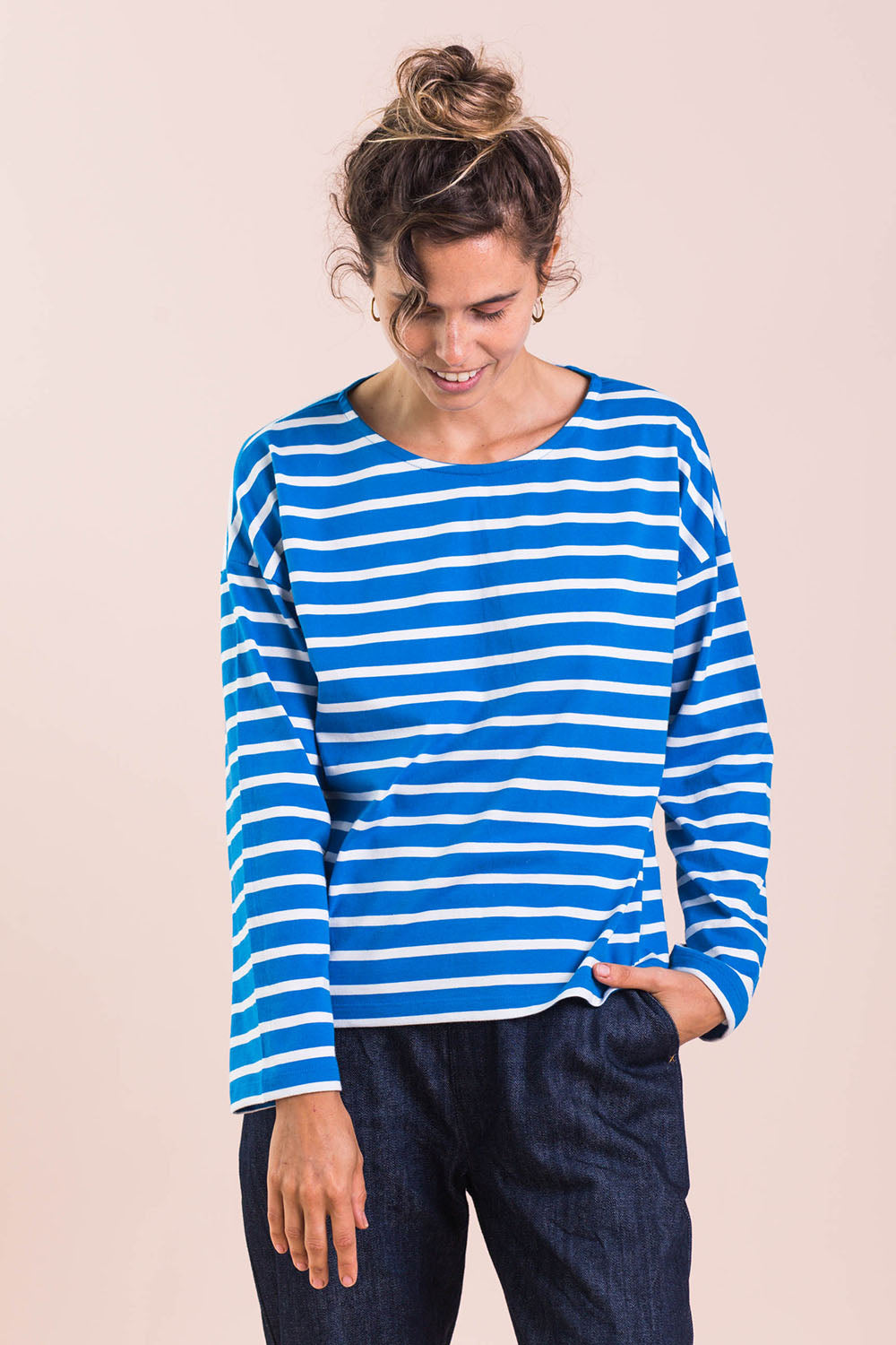A model wearing the Brigitte Tee in colour Cobalt (Blue), from the front, cropped image